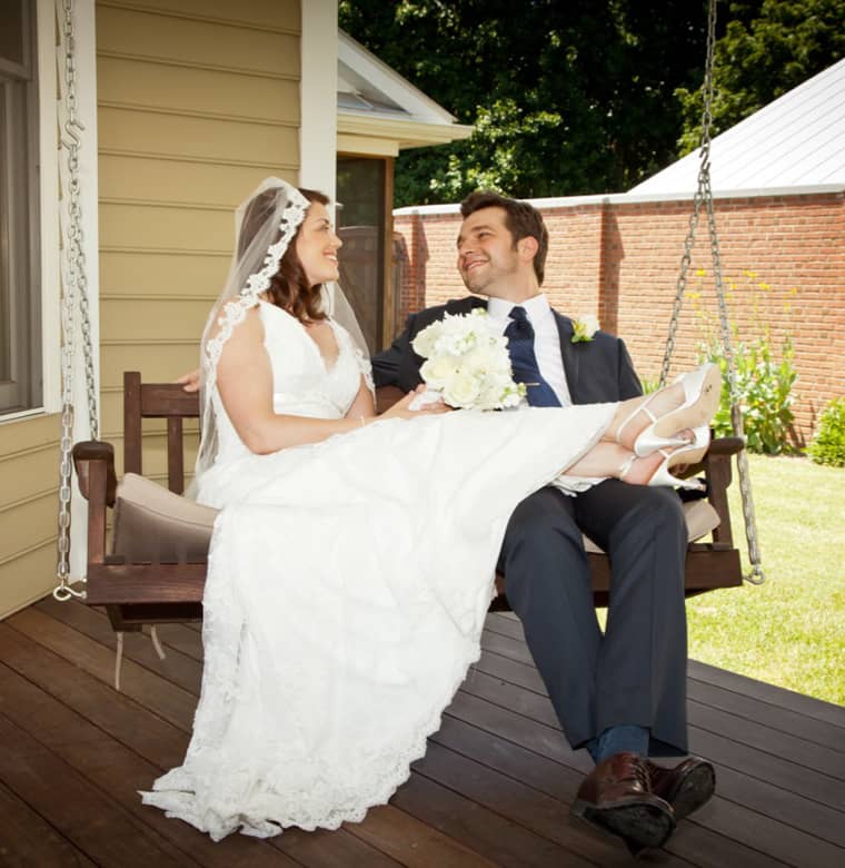 Bride and Groom lounging on a bench swing