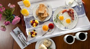 Breakfast tray with eggs, toast, fruits, coffee, etc.