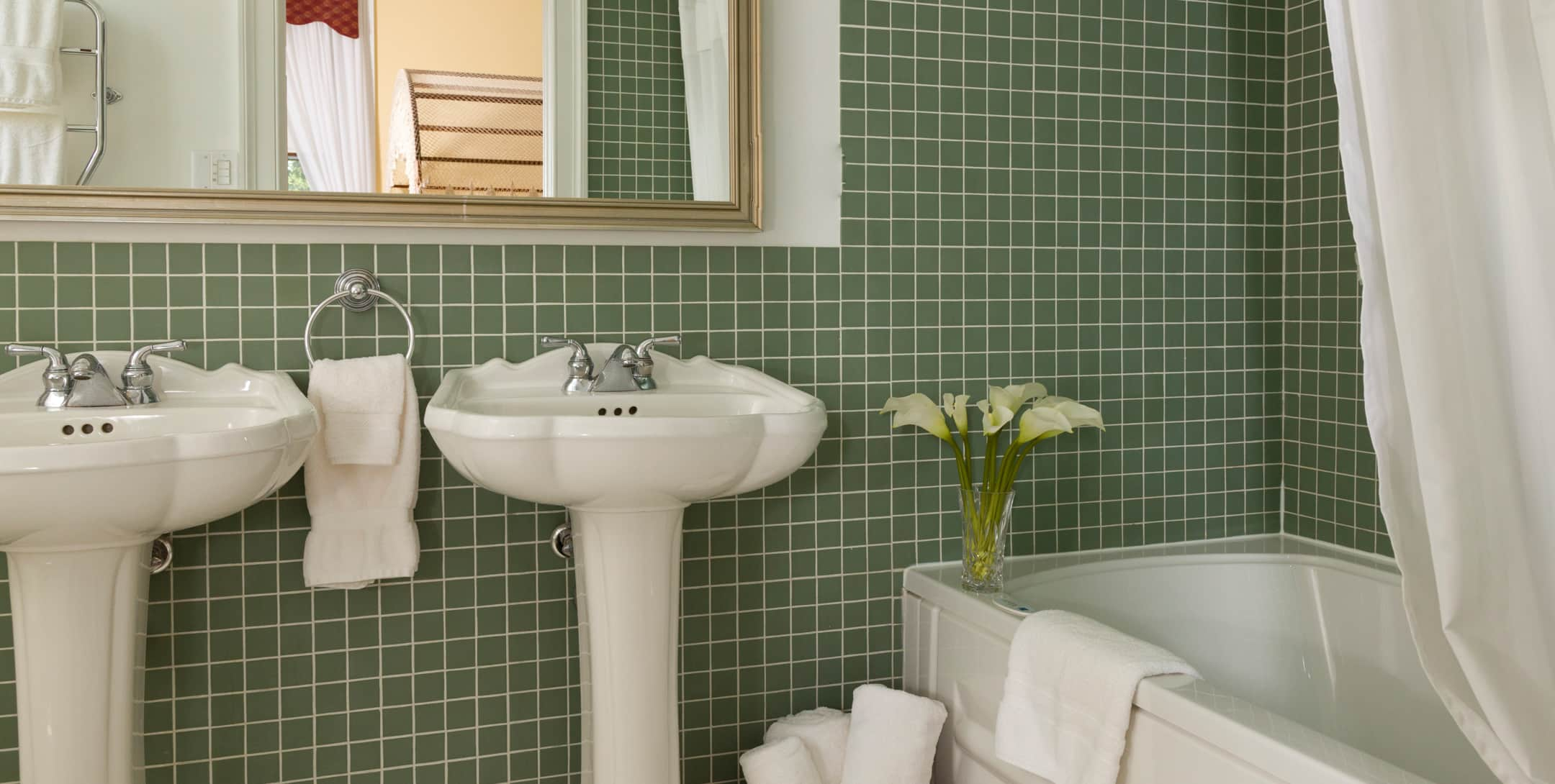 Bathroom with green tile and a shower/tub combination in the Yellow Room at Brampton Inn