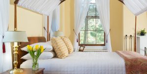 The Yellow Room at Brampton Inn with a queen bed and fireplace